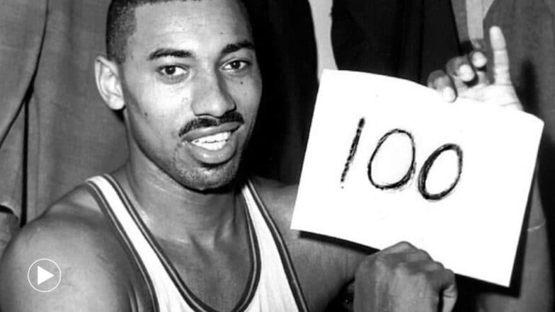 Wilt Chamberlain holds a sign to reference his 100-point performance