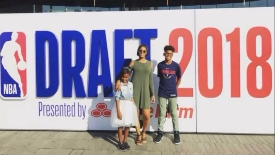 Chris Cenac Jr., a 2026 NBA Draft pick, poses in front of the 2018 NBA Draft banner as a teenager.