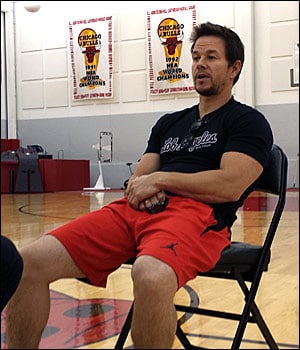 Mark Wahlberg sits on the court at the Berto Center